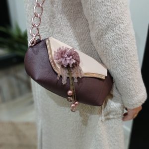 Vue du sac poudré en cuir surcyclé, porté sur un moèle, avec bijou intégré de seconde main.