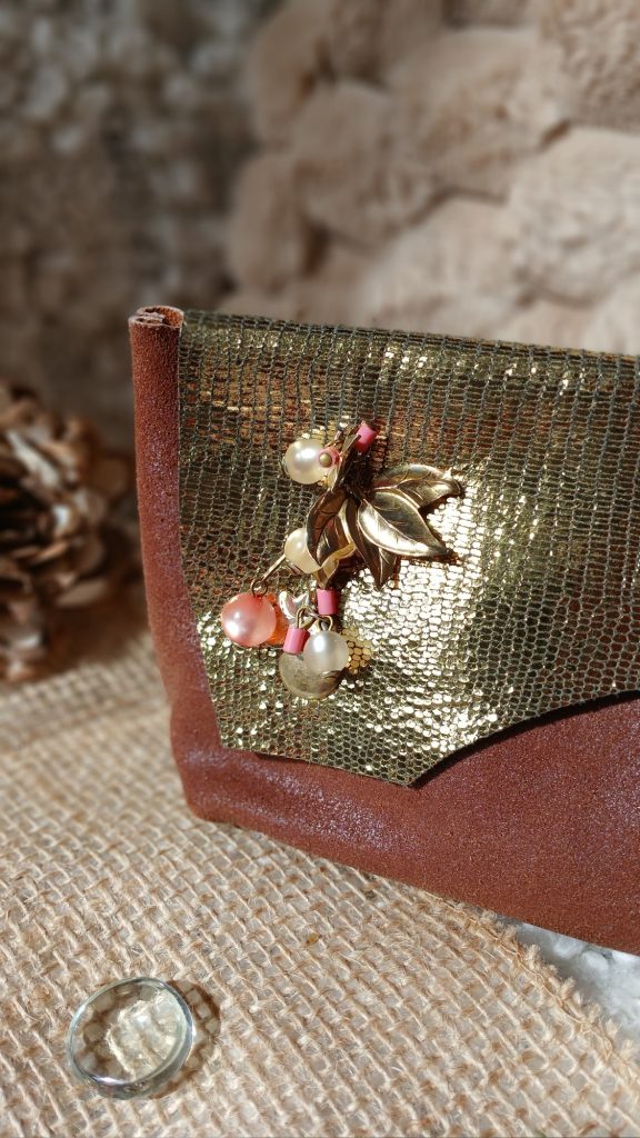 Vue sur le bijou de la pochette Isis en cuir surcyclé, élégant et singulier, fait main.