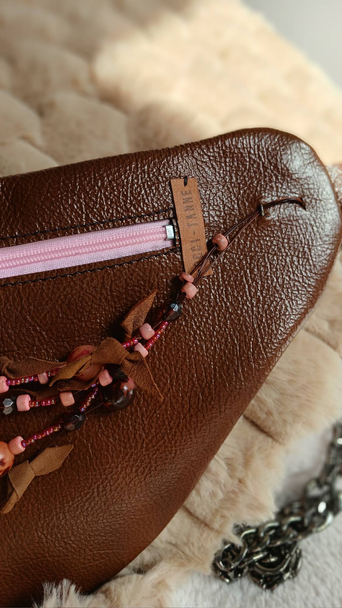 Vue zoomée sur le coller de seconde main du sac banane Arborea en cuir upcyclé, fait main. Avec ses tons marrons et roses, féminité assumée. Une création artisanale, unique et écoresponsable.