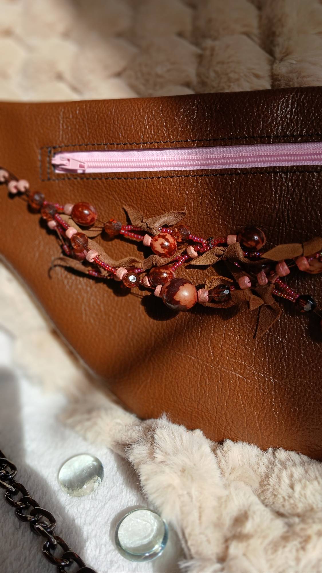 Vue zoomée sur le coller de seconde main du sac banane Arborea en cuir upcyclé, fait main. Avec ses tons marrons et roses, féminité assumée. Une création artisanale, unique et écoresponsable.