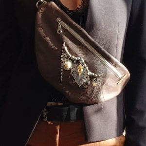 Vue portée de loin du sac banane Automne, marron et noir en cuir surcyclé. Un collier de seconde main pour le sublimer, un style unique. Un accessoire élégant, féminin et singulier, fait main.