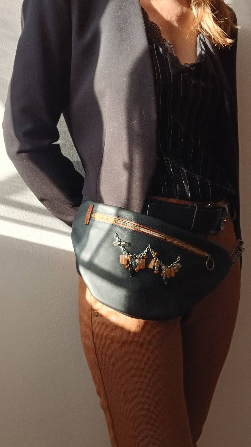 Vue portée de près façon ceinture du sac banane Sépia, en cuir surcyclé. Avec son collier de seconde main au style ethnique, il est un accessoire élégant, féminin et singulier, fait main.