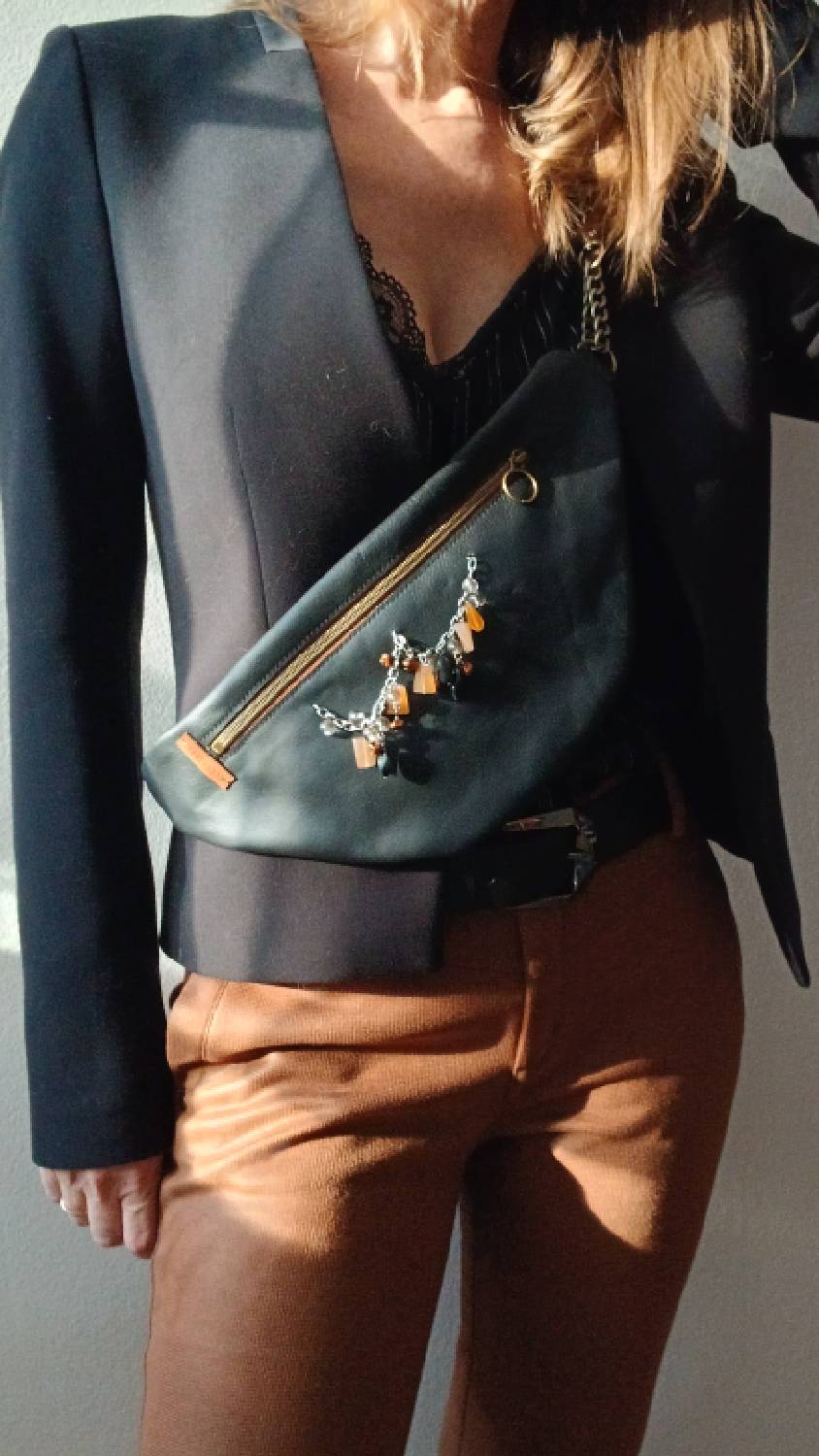 Vue portée de près du sac banane Sépia, en cuir surcyclé. Avec son collier de seconde main au style ethnique, il est un accessoire élégant, féminin et singulier, fait main.