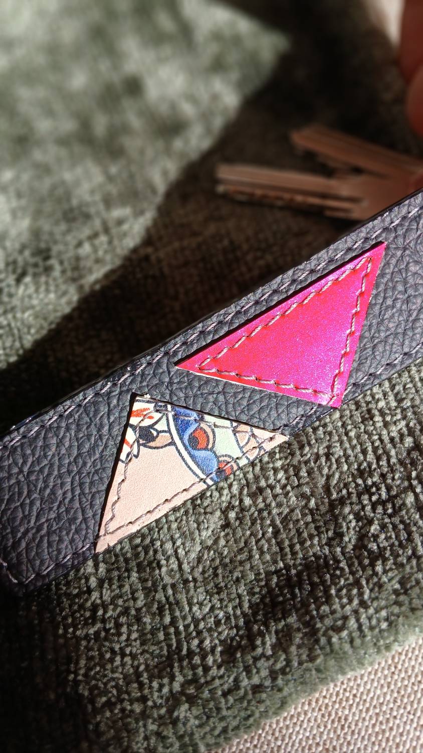 Vue zoomée du porte-clés Coq'Uette en cuir surcyclé rouge et noir. Il reprend une chute de cuir à motif coq et un cuir rouge ciré. Il fait partie de la catégorie les Complices « Coq'Uette ». C'est un accessoire féminin, unique, affirmé, fait main.