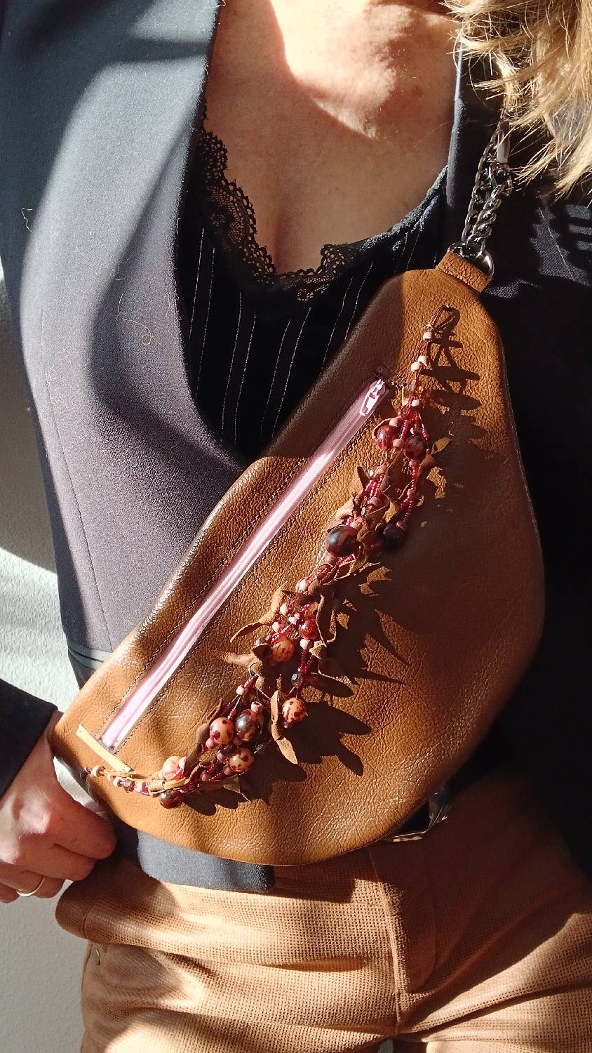 Vue portée de près du sac banane Arborea en cuir upcyclé, fait main. Avec ses tons marrons et roses, féminité assumée. Une création artisanale, unique et écoresponsable.