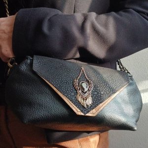 Vue portée du sac Galante, de la catégorie Les Complices Galante, en cuir upcyclé noir et bronze, fait main. Avec ses tons subtiles et son bijou de seconde main assorti, féminité assumée. Une création artisanale et unique.