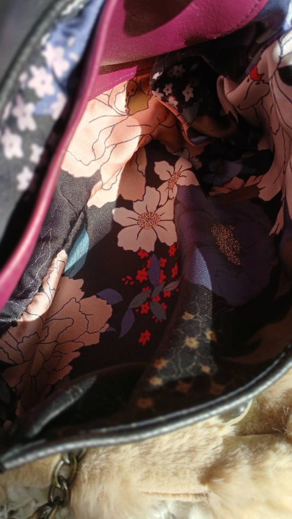 Vue intérieure du sac Galante, de la catégorie Les Complices Galante, en cuir upcyclé. La doublure est un tissu surcyclé avec des motifs floraux aux tons rosé et bordeaux sur fond noir. Une création artisanale et unique.