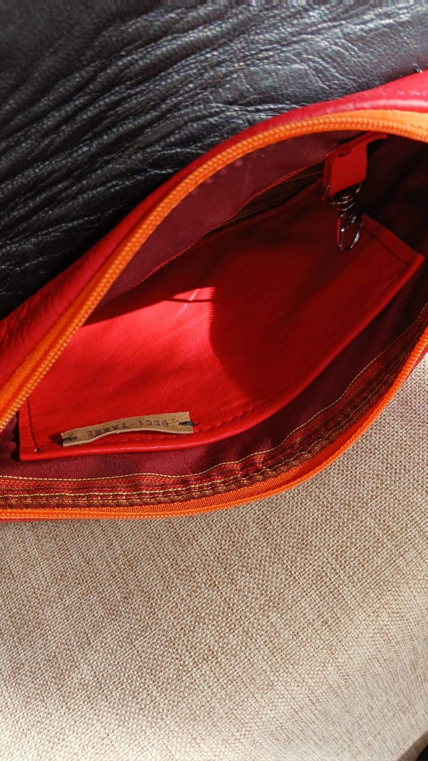 Vue sur la poche intérieure en cuir rouge. Le sac Serpentine en cuir upcyclé rouge et motif serpent est accessoire féminin, pratique, affirmé, fait main.