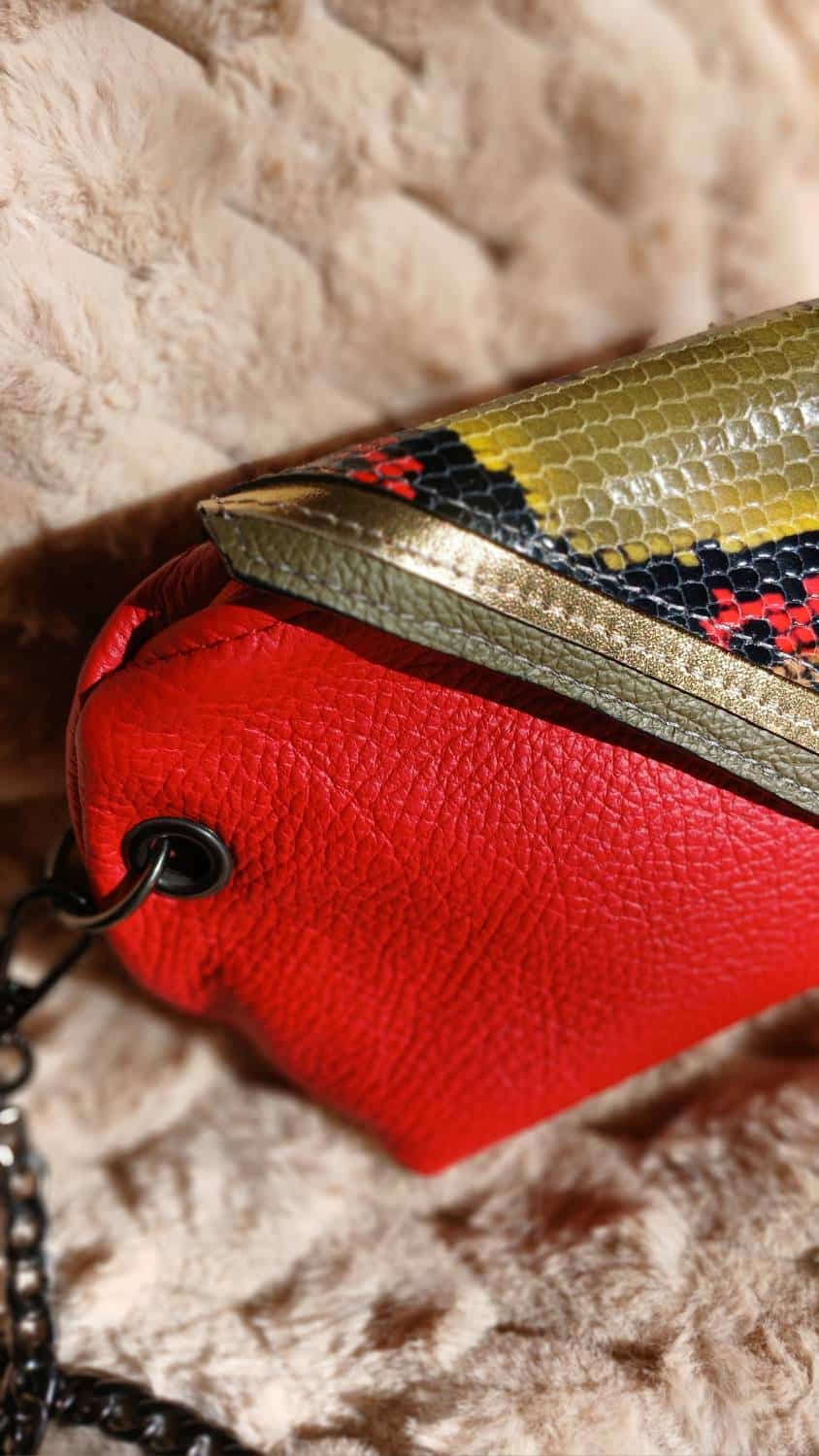 Vue zoomée sur le rabat du sac Serpentine en cuir surcyclé rouge et motif serpent. C'est un accessoire féminin, élégant, affirmé, fait main.