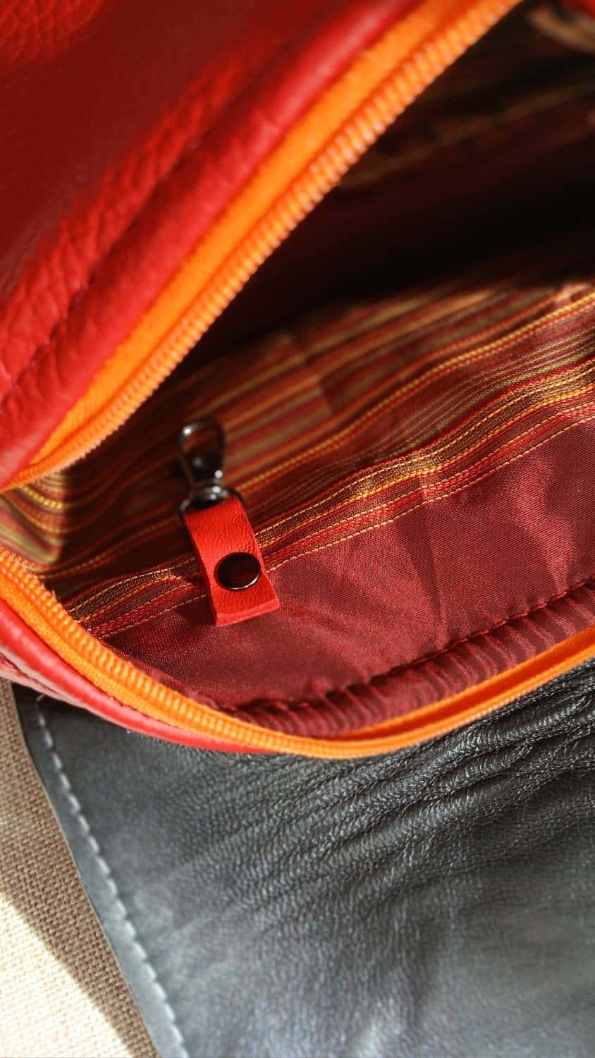 Vue intérieure du sac Serpentine en cuir surcyclé rouge et motif serpent. Accroche par mousqueton. Un accessoire féminin, élégant, affirmé, fait main.